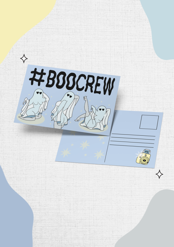 A postcard on a textured background displays the hashtag "#BOOCREW" with illustrations of cute, playful ghosts. The back of the postcard is visible, showing space for an address and a stamp. There is also a small illustration of a camera in the bottom right corner.