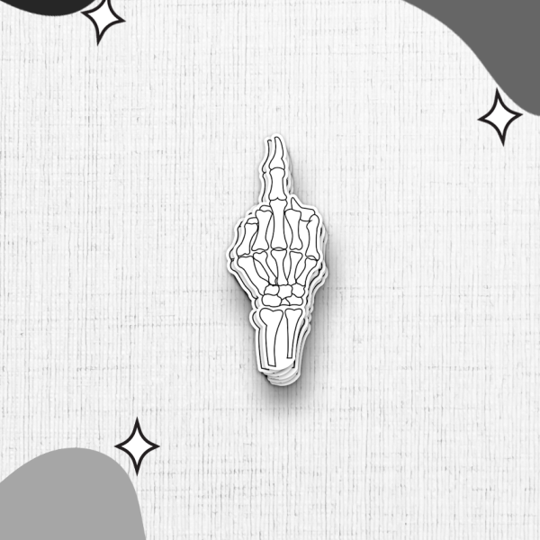 A skeleton hand sticker is a minimalist black and white illustration depicting a skeleton hand giving the middle finger, set against a white textured background. The corners of the image are adorned with abstract, irregular black and grey shapes and small star-like accents.