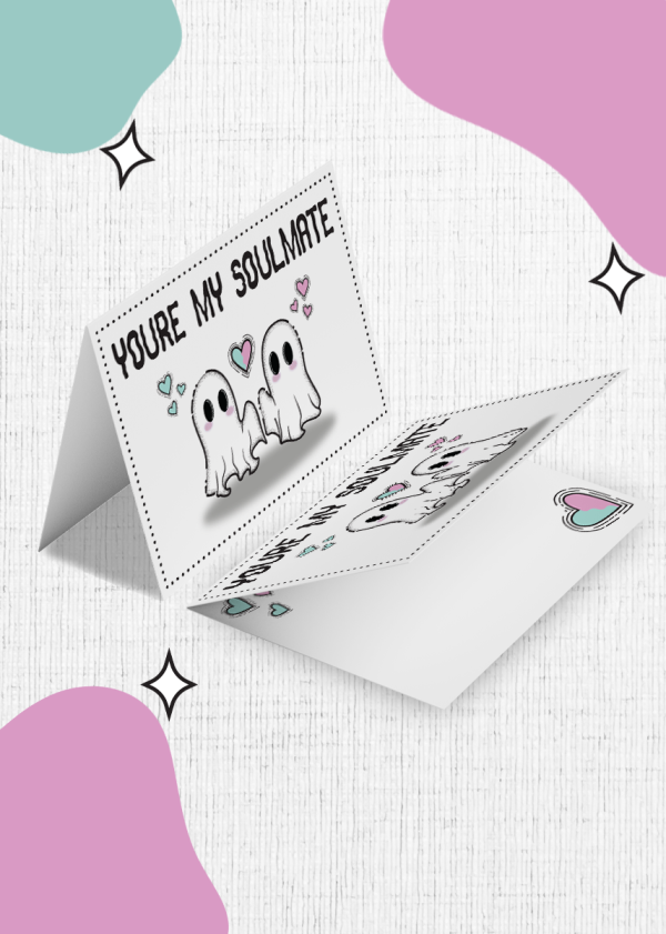 You're My Soulmate Valentines Card features a charming cartoon design of two adorable ghosts holding hands. The card is open, displaying the front message 'You're my soulmate,' surrounded by hearts around the ghosts. The background is a white canvas adorned with pink, teal, and purple blobs and star motifs.