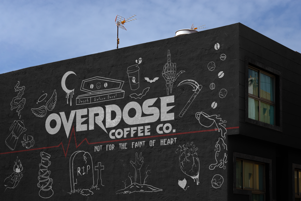 A building painted a mural. The wall is black with text and illustrations is white, with a red heartbeat line accross the length of the building. The text reads "Overdose Coffee Co.". The illustrations include broken cups, a percolator, a grave, a devil heart, coffee beans and skulls and a coffin.