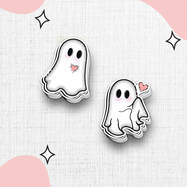 Two ghost cartoon stickers with rosy cheeks on a textured white background. One ghost is simple while the other is holding a pink heart with a wink. The background is decorated with soft pink blob shapes and small black star accents.